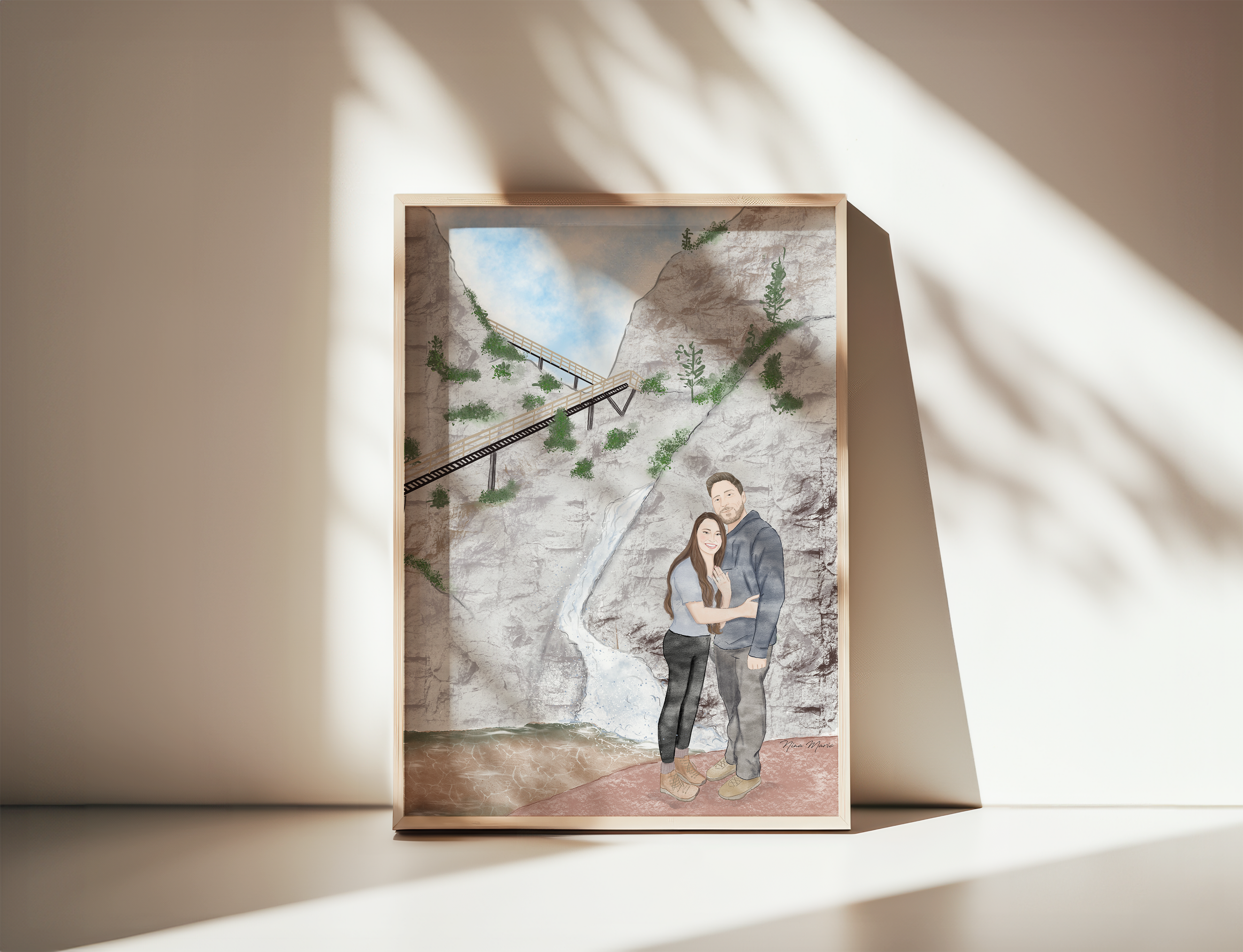 Framed engagement artwork of a couple embracing in front of a stone wall with a staircase by Nina Maric