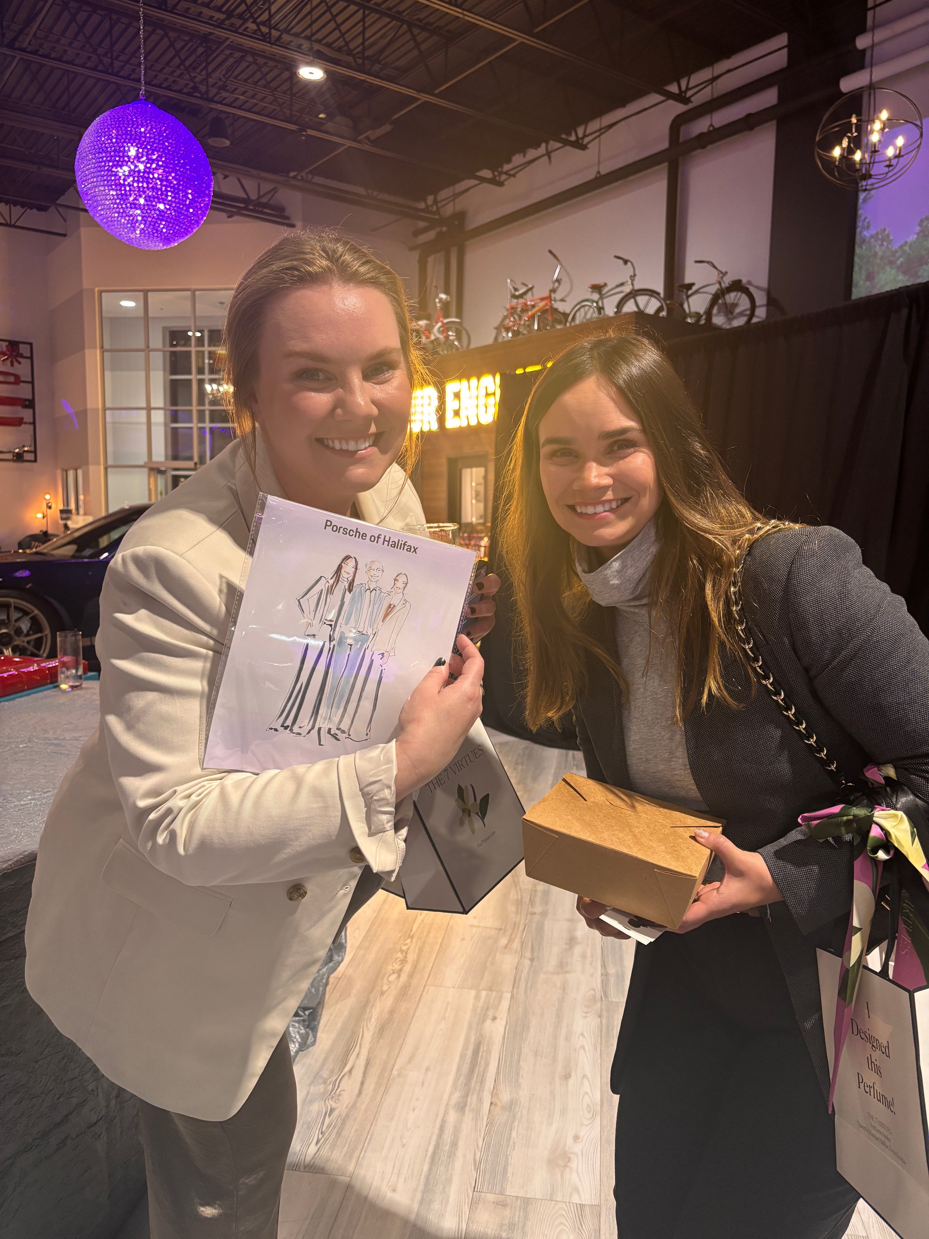Two women interacting with a box and paper in an indoor setting