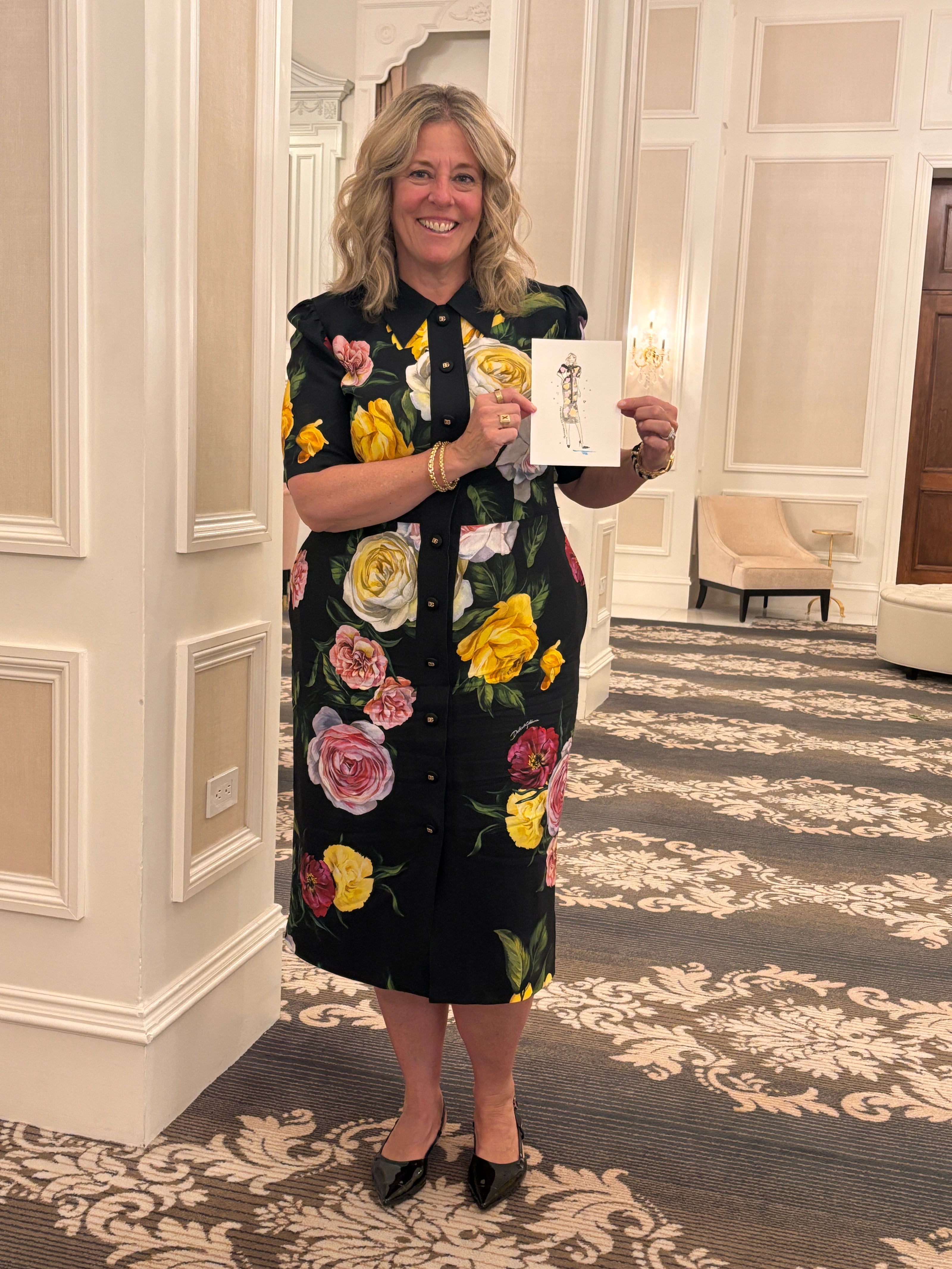 Woman holding a card in a room with Nina Maric fashion art
