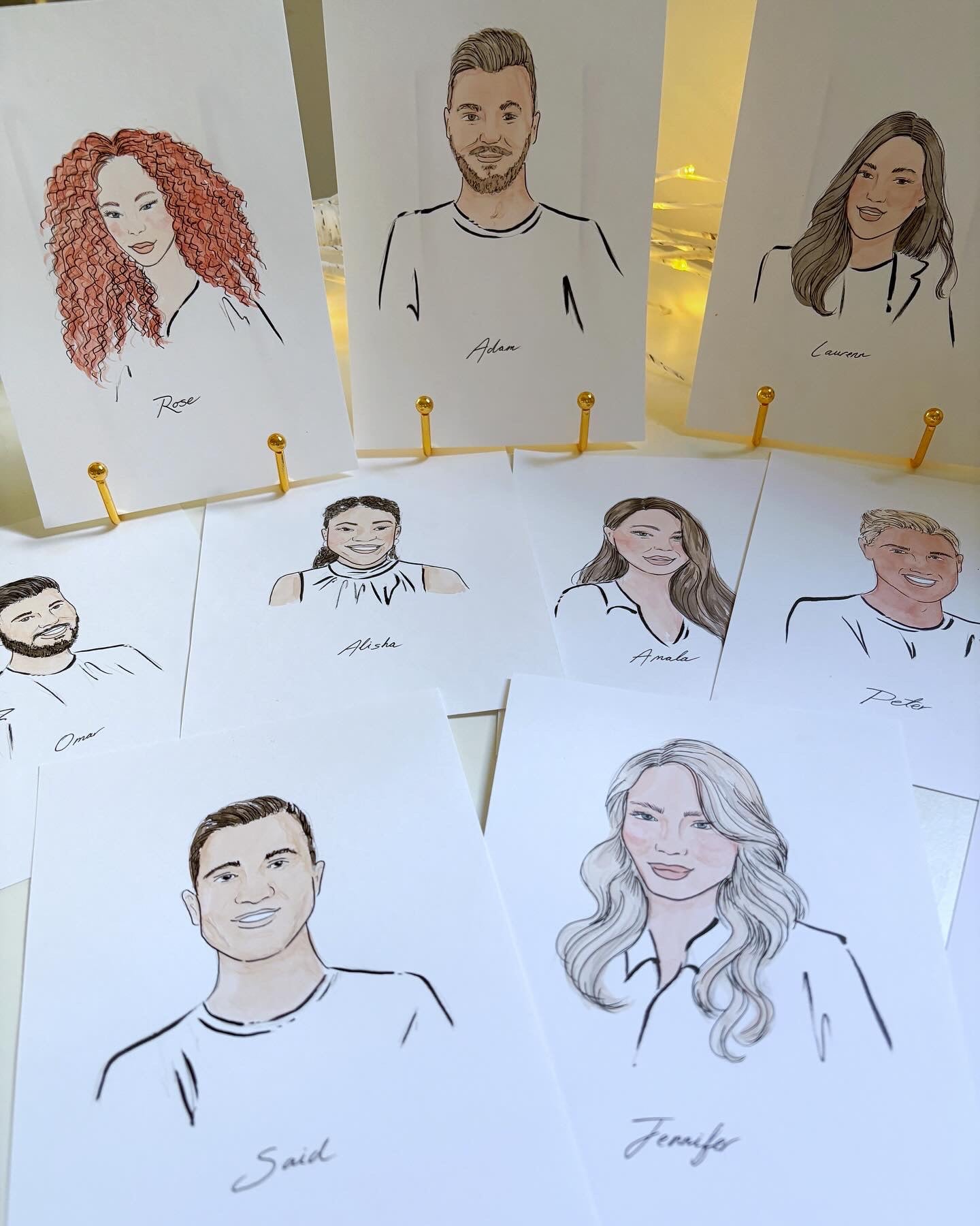 Illustrations of people on small cards with names underneath, displayed on a stand.